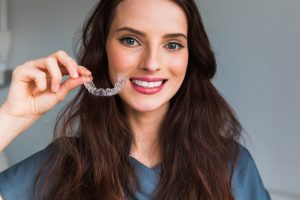 woman holding aligner