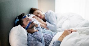 man sleeping using CPAP machine