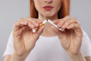 woman breaking cigarette in half